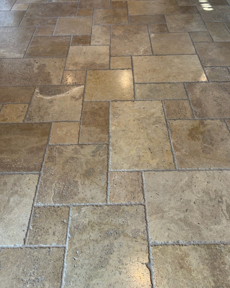 Dull, dirty travertine tile floor before cleaning by Empire Grout in Phoenix